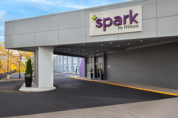 A hotel entrance with a 'spark by Hilton' sign, a covered walkway, and potted plants. - Spark by Hilton Toronto Airport (Toronto)