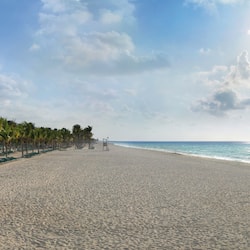 On the beach, white sand, sun loungers, beach towels