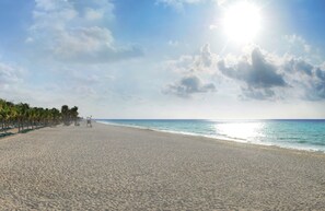 On the beach, white sand, sun loungers, beach towels