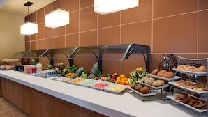 Un buffet proposant une variété de plats et une présentation de fruits.