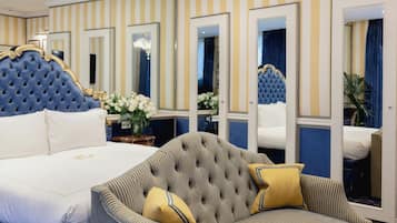 Ein Hotelzimmer mit einem großen Bett, einer Couch und mehreren Spiegeln.
