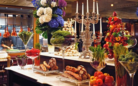 A buffet table with various food items and decorative elements.