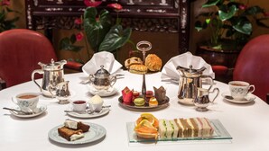 A table set for a tea service with various pastries and a cake. - Washington Mayfair Hotel (London)