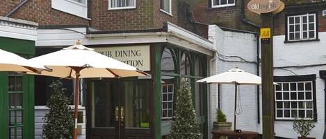 Un pub traditionnel doté d’une terrasse, une enseigne indiquant « The Bear » et une autre indiquant « Salle à manger ».