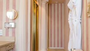 A bathroom with striped walls, a sink, a mirror, and a towel rack. - Hostellerie de la Pommeraie by Popinns (Sélestat)