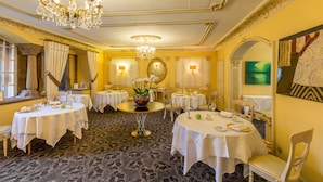 A dining area with round tables, chandeliers, and a mirror. - Hostellerie de la Pommeraie by Popinns (Sélestat)