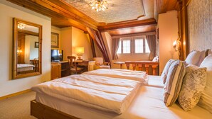 A bedroom with a large bed, a desk, a chair, a television, and a mirror. - Hostellerie de la Pommeraie by Popinns (Sélestat)