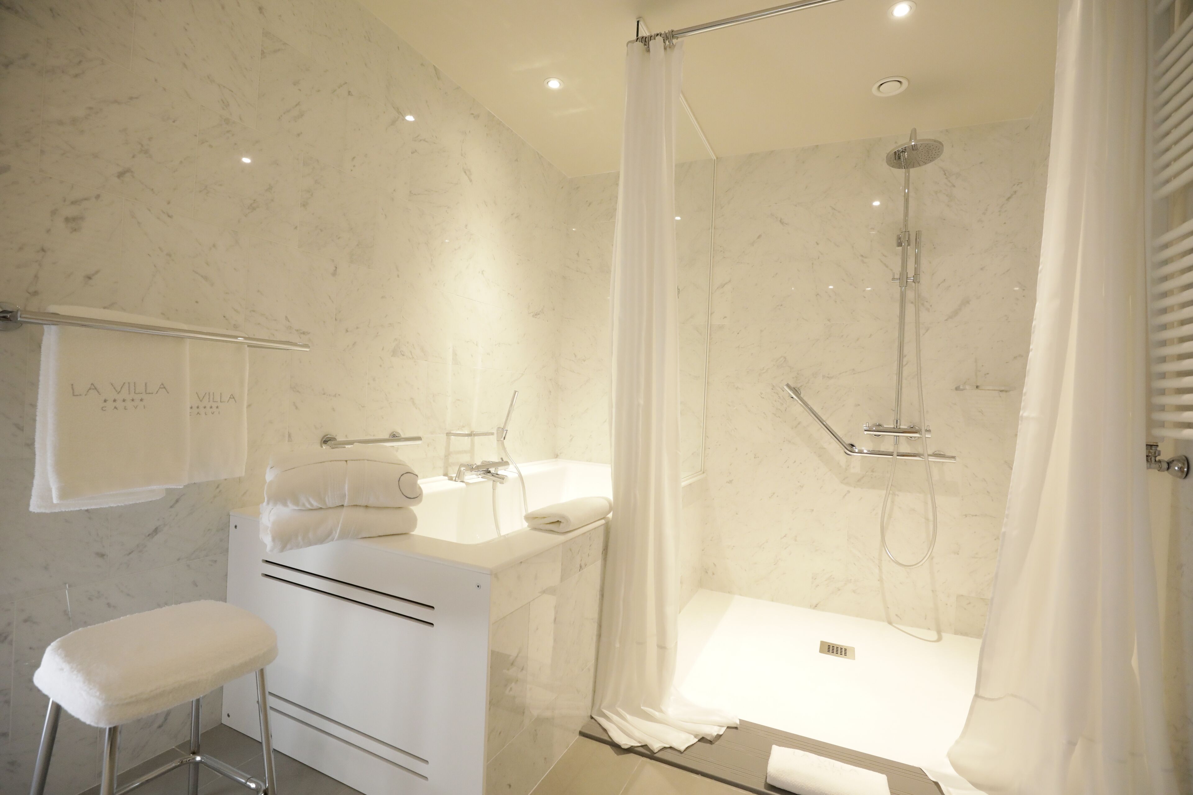 A modern bathroom with a shower, a bathtub, and a vanity with a mirror.