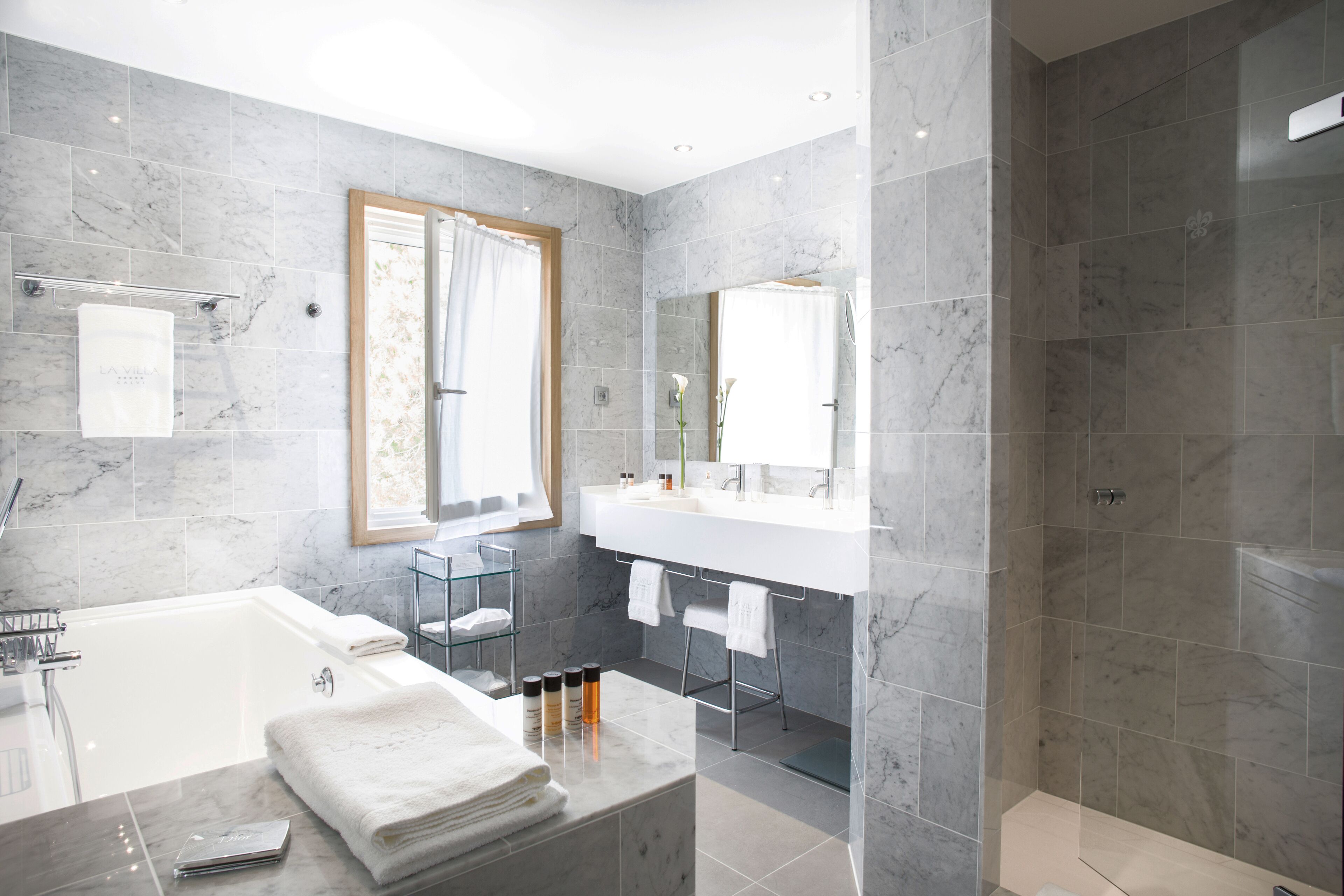 A modern bathroom with a bathtub, a shower, and a vanity with a mirror.