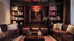 A library with leather sofas, a chessboard, and bookshelves. - Hotel Alden Splügenschloss Zürich - Leonardo Limited Edition (Zürich)