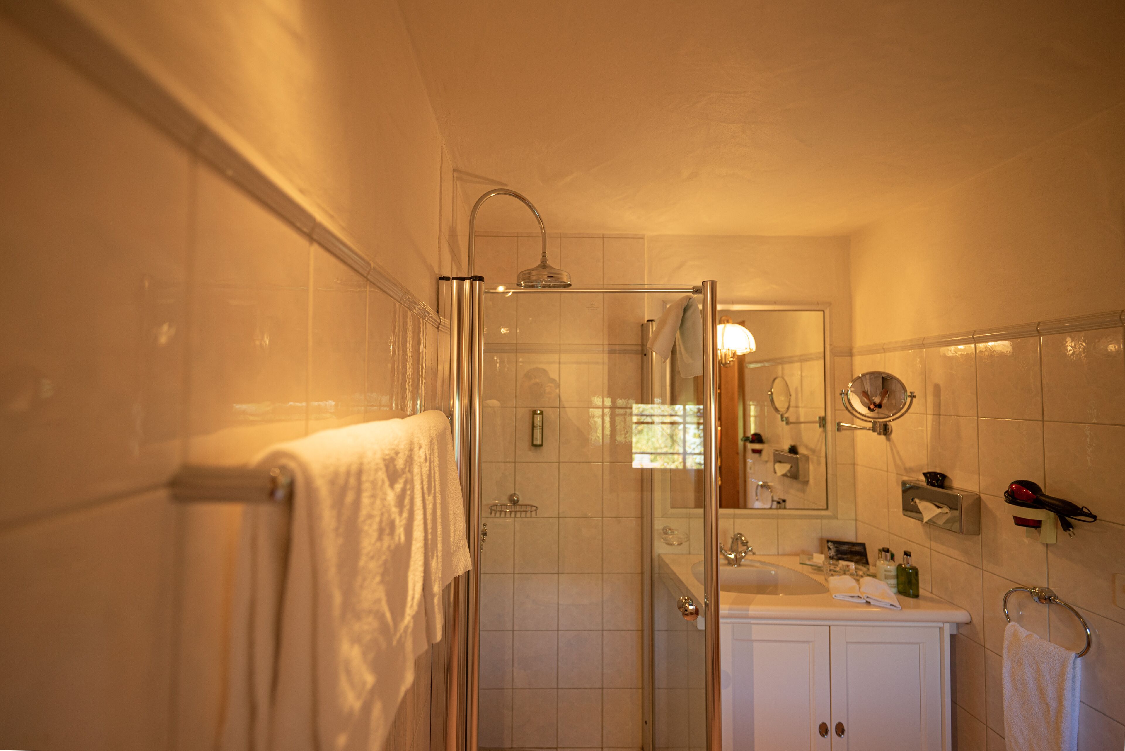 Ein Badezimmer mit Duschkabine, Waschbecken und Spiegel.