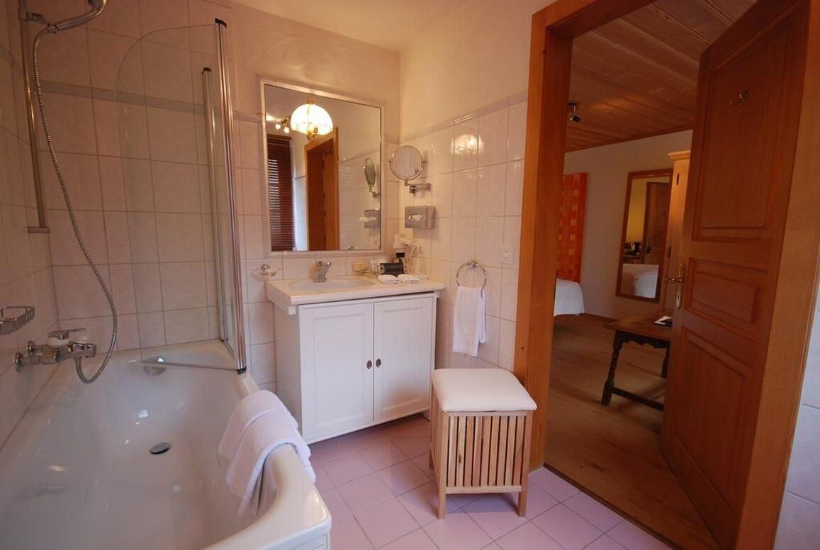 A bathroom with a bathtub, a shower, a sink, and a vanity.
