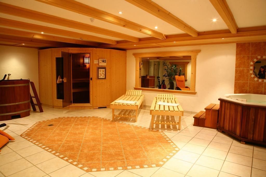 Une pièce spacieuse avec un plafond en bois, une grande moquette, un jacuzzi et des bancs en bois.