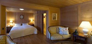 A cozy room with a bed, a sofa, and two bedside tables with lamps.