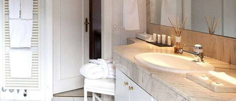 Un baño moderno con un lavamanos grande, un espejo y un perchero para toallas.