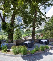 Un patio con mobiliario exterior y vistas a un paisaje montañoso.