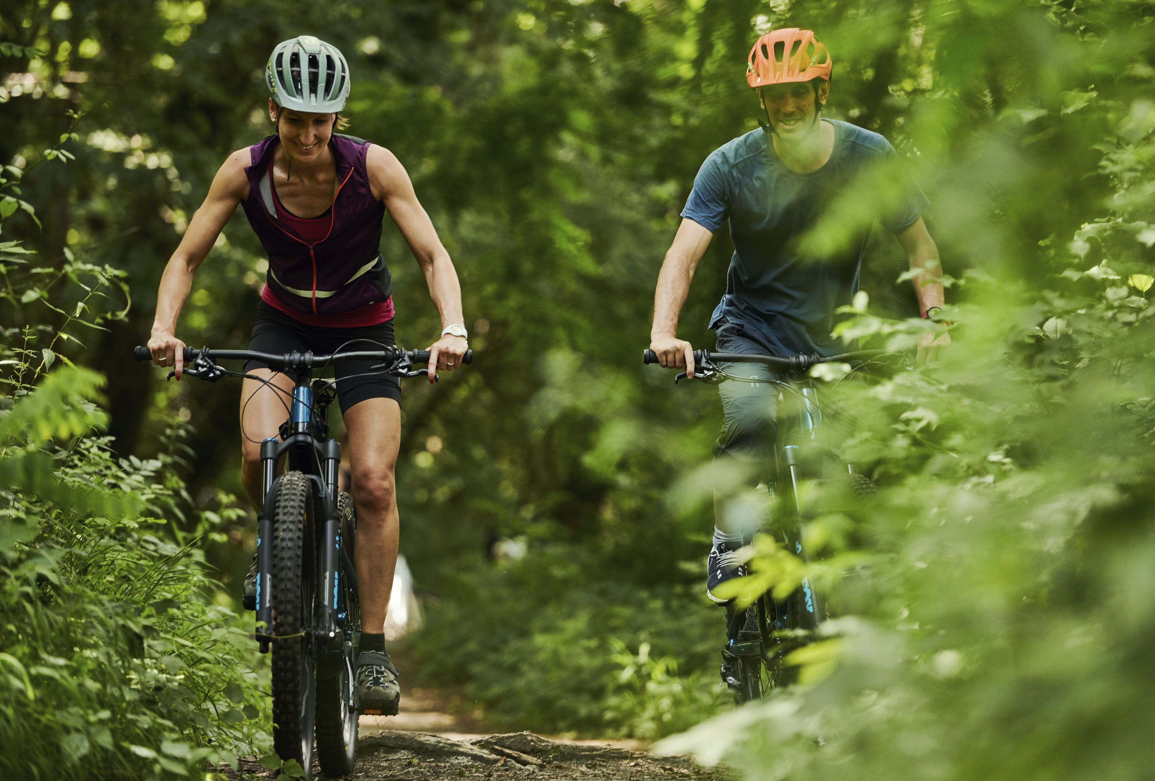 Dos ciclistas en un sendero boscoso.