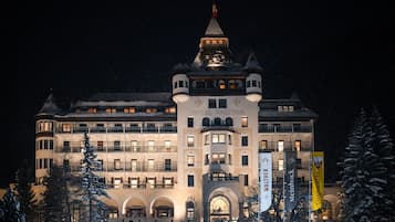 A large, historic building with a prominent tower and multiple balconies.