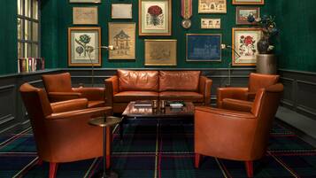 A room with a leather sofa set, a coffee table, and a patterned carpet.
