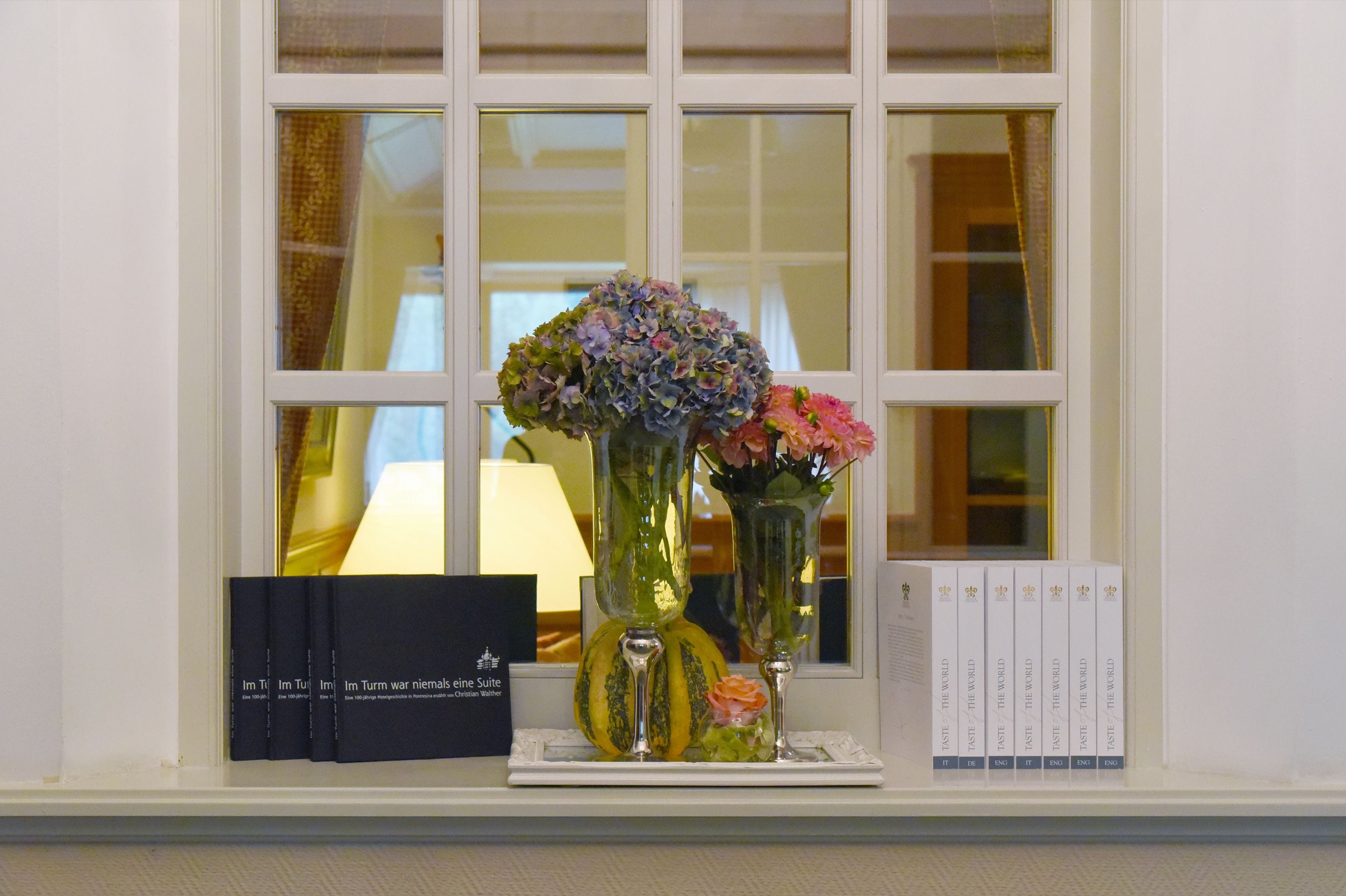 A window with books and vases on a windowsill.