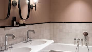 Un baño moderno con dos lavamanos, una bañera y un espejo grande con iluminación.