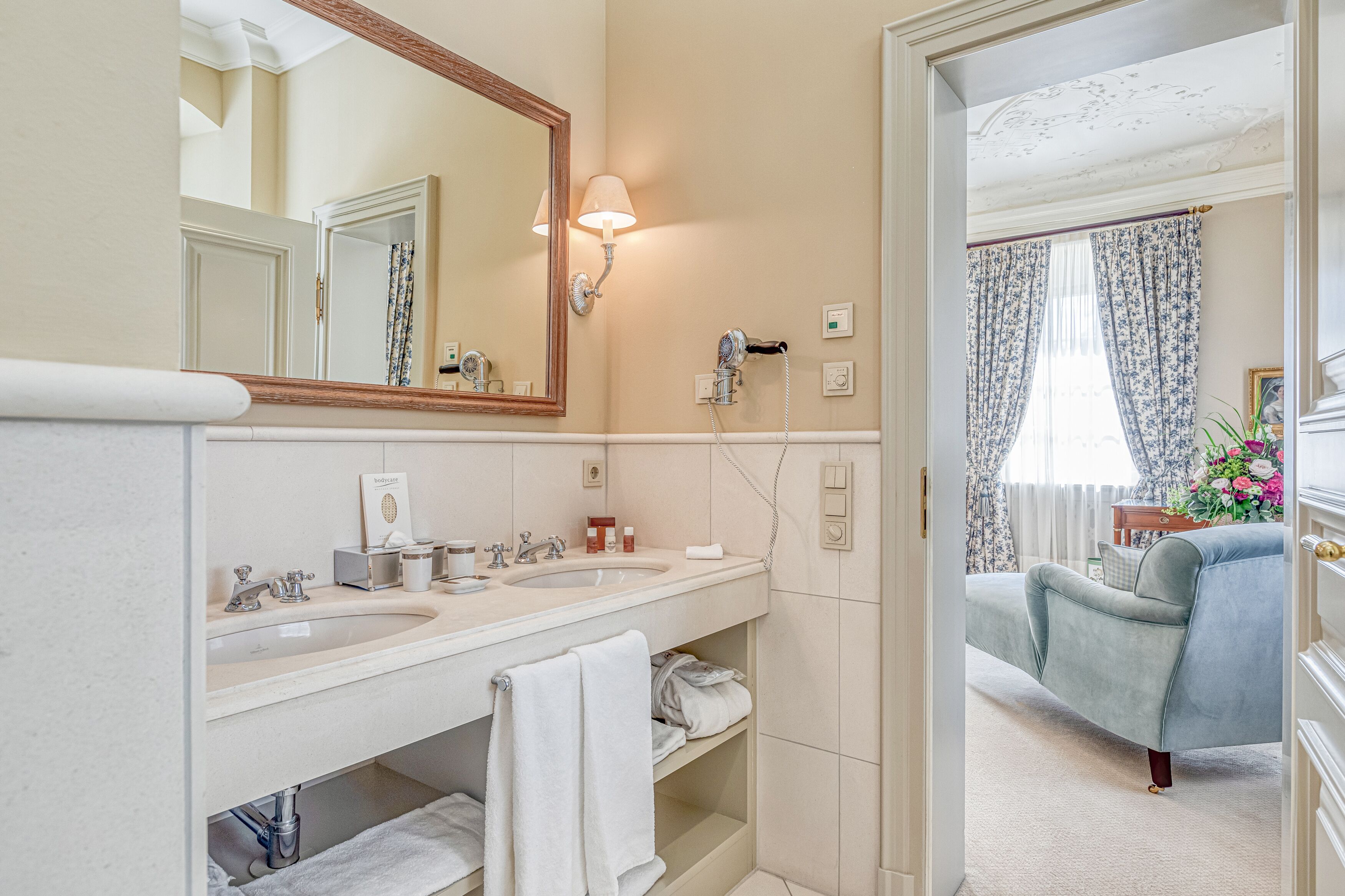 A bathroom with two sinks, a large mirror, and a towel rack.