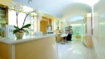 Welcome to our reception area, featuring a central desk, comfortable seating, and beautiful artwork.