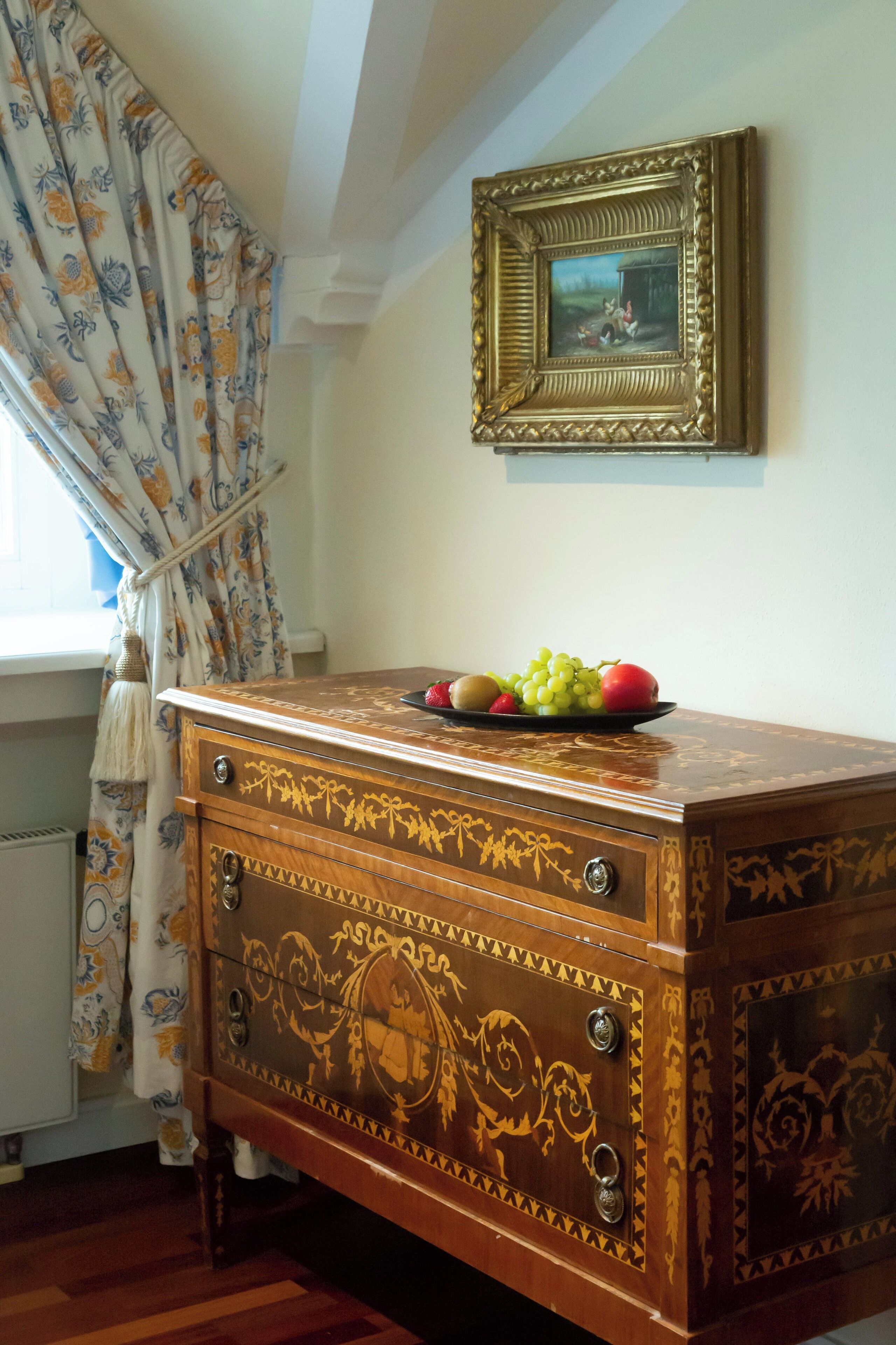 Een houten dressoir met ingewikkelde houtsnijwerken en een schaal fruit erop.