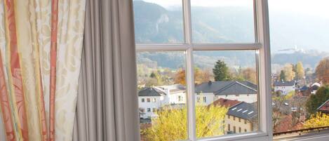 Una ventana con vistas a un pueblo y montañas.