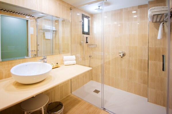 A modern bathroom with a large white sink, a glass shower enclosure, and a mirror above the sink. - Hotel Servigroup Montíboli (Villajoyosa)