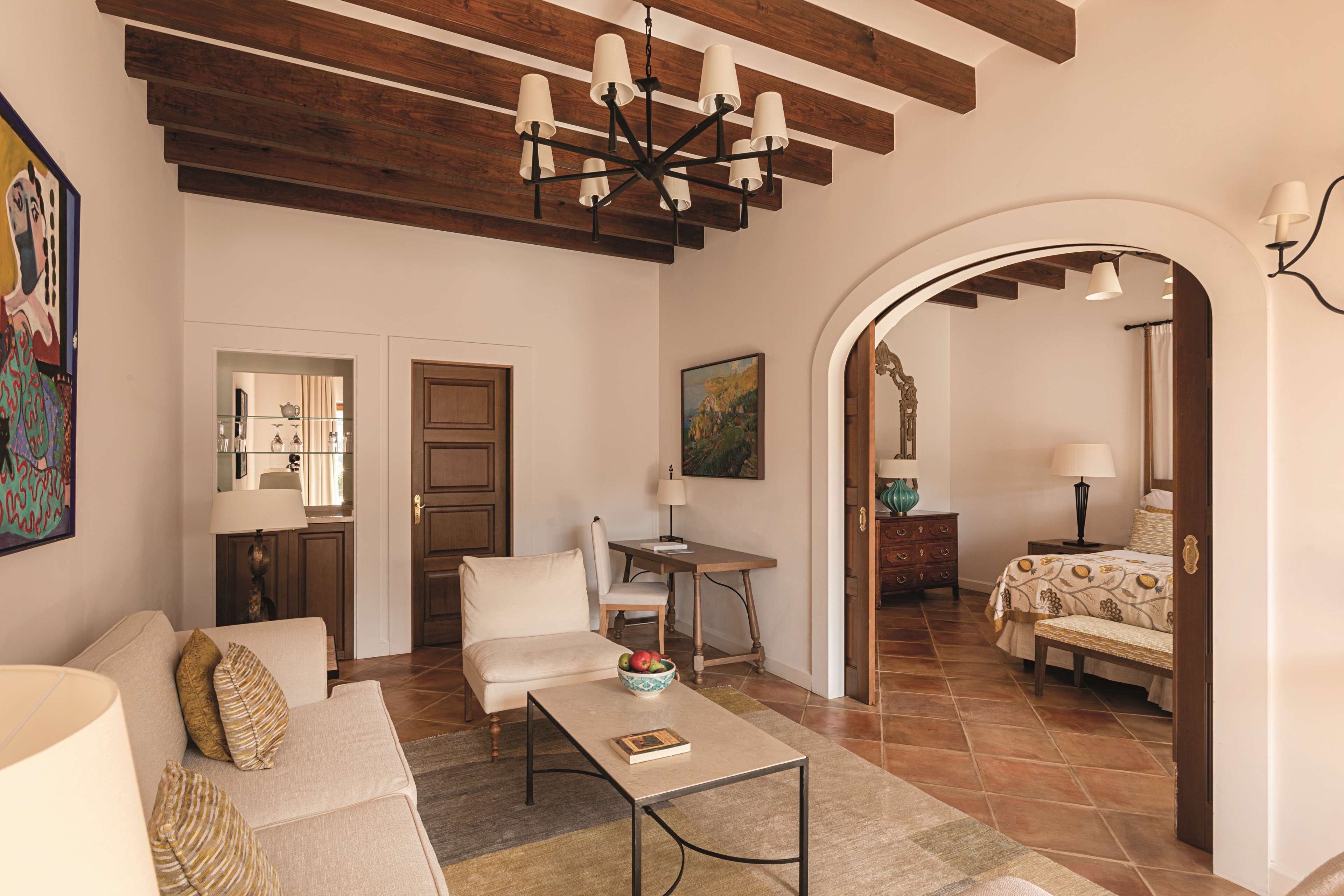 A living room with a sofa, coffee table, and a painting on the wall.