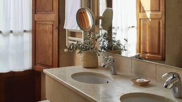 Un baño con dos lavamanos, un espejo y una planta en maceta.