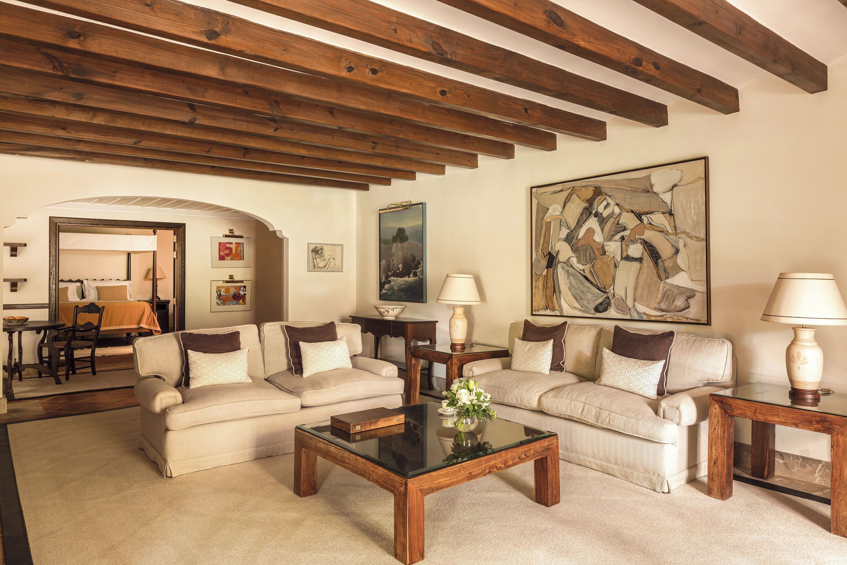 A living room with two sofas, a coffee table, and a painting on the wall.