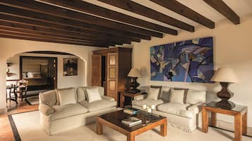 Ein Wohnzimmer mit zwei Sofas, einem Couchtisch, Lampen und einem Gemälde an der Wand.