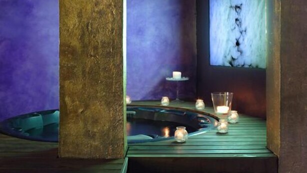 A spa area with a wooden floor, a small pool, and candles. - Rusticae Hotel Casa del Abad (Ampudia)