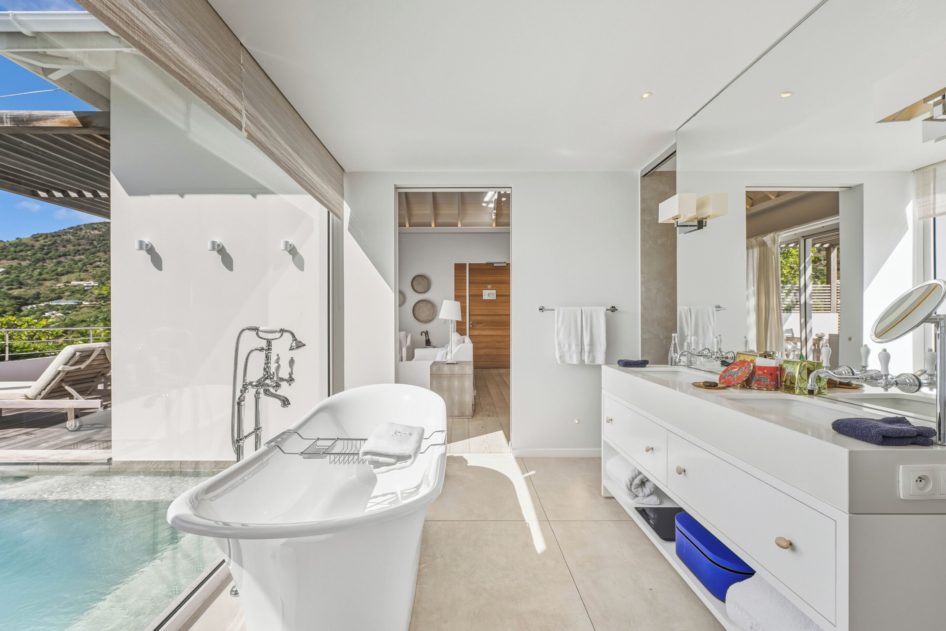 Un bagno moderno con una vasca, uno specchio grande e un mobile lavabo.
