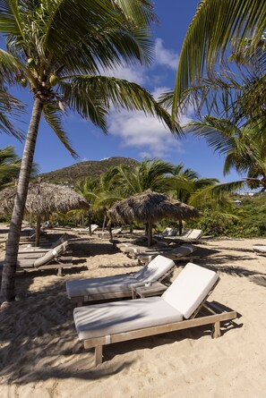 On the beach, white sand, sun loungers, beach towels