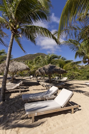 On the beach, white sand, sun loungers, beach towels