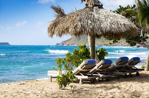 On the beach, white sand, sun-loungers, beach towels
