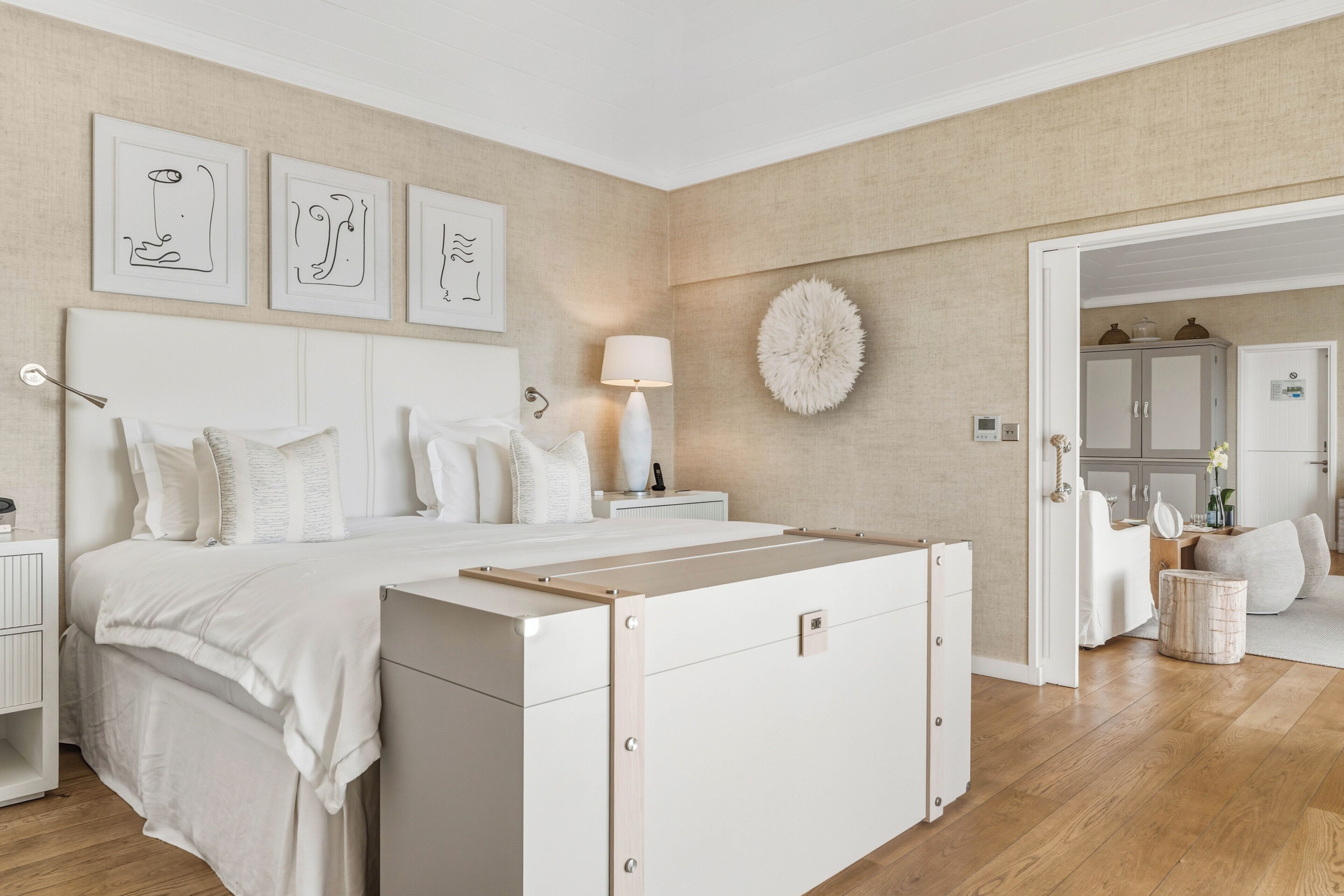A bedroom with a bed, bedside tables, a lamp, and artwork on the wall.