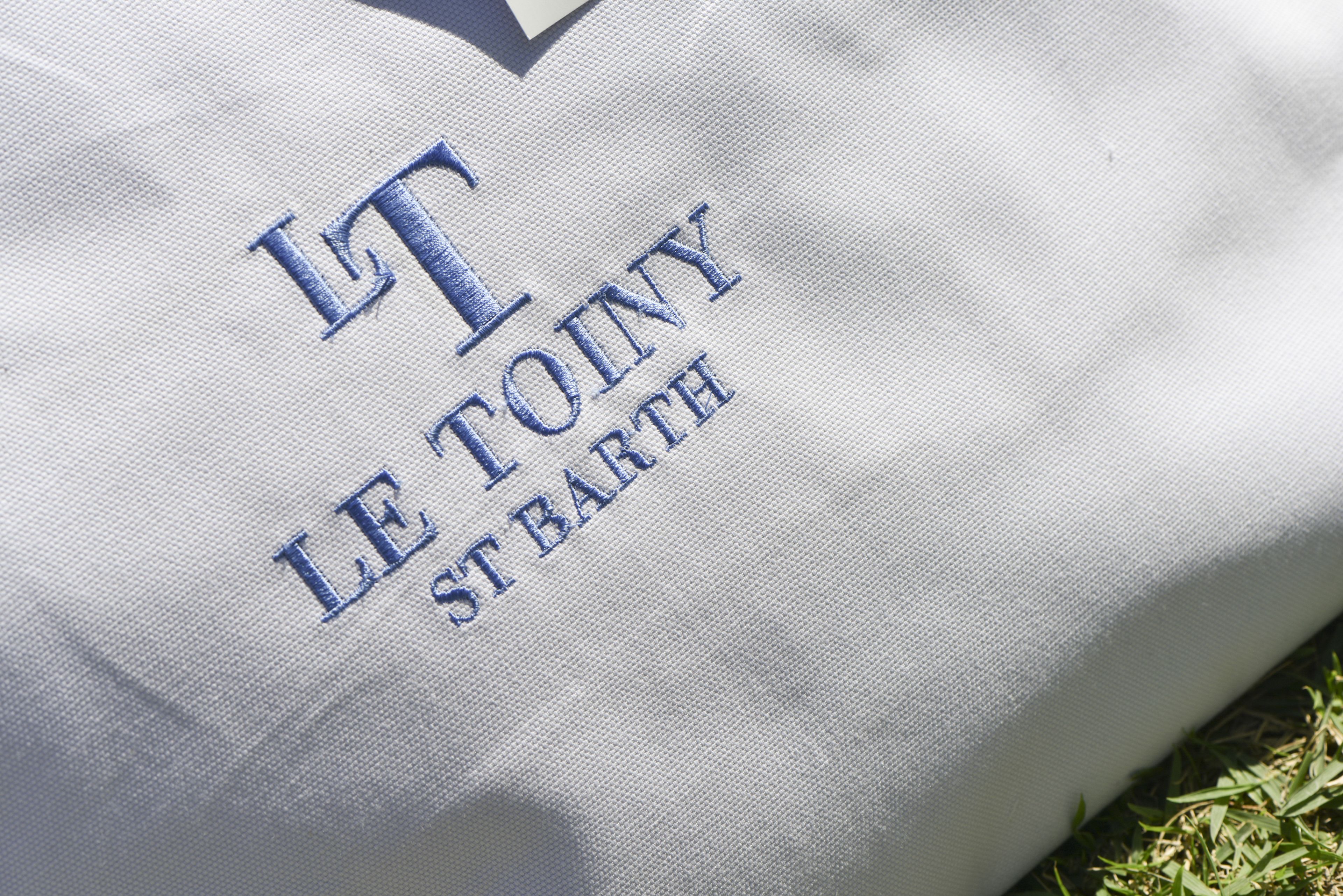 A fabric with embroidered text reading "LT LE TOINY ST BARTH".