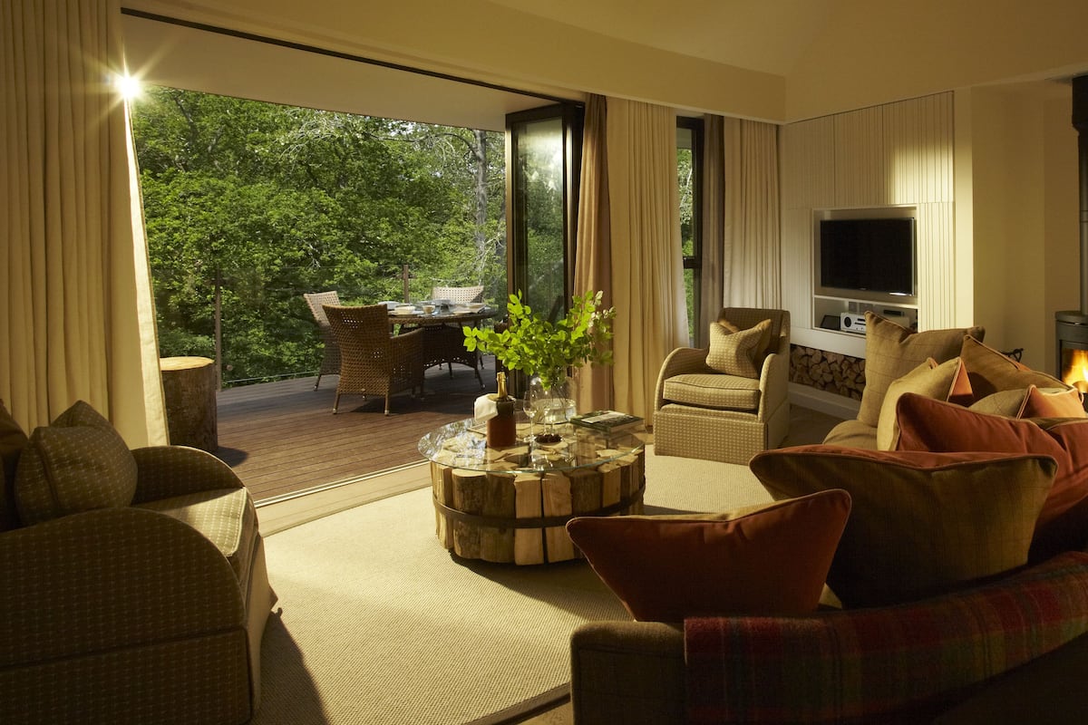 A cozy living room with a fireplace, comfortable seating, and a dining area with outdoor views.