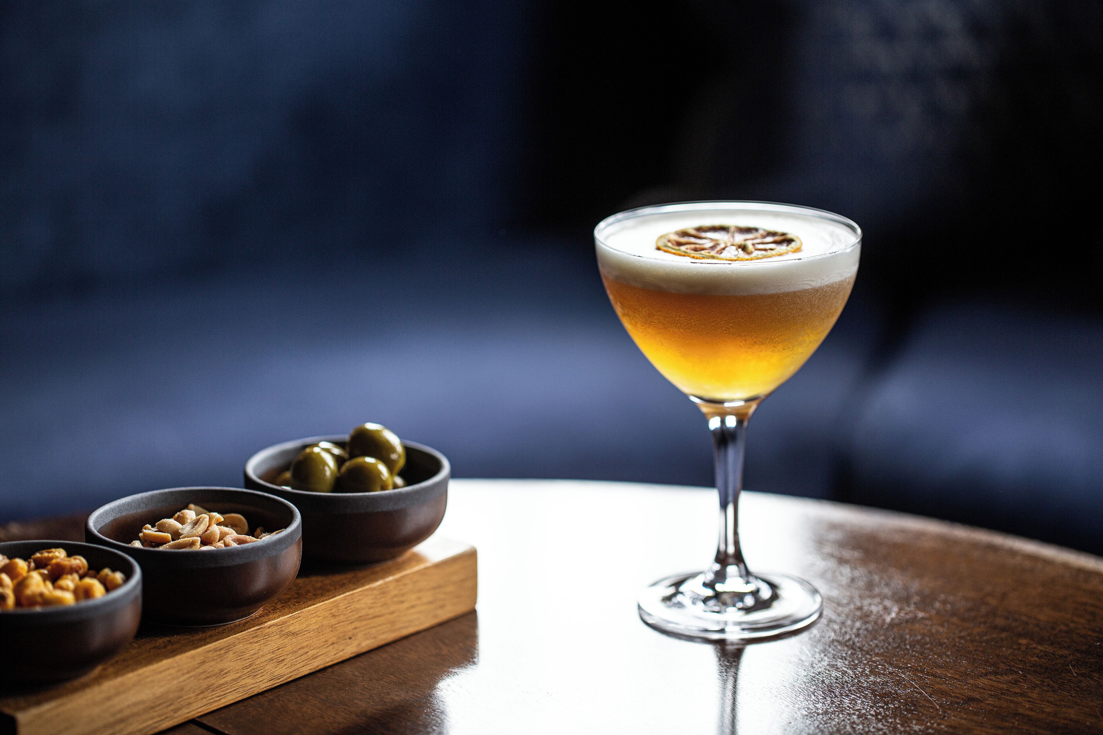 Una copa de martini con espuma sobre una mesa de madera.