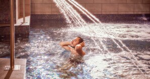 Una piscina cubierta, tumbonas