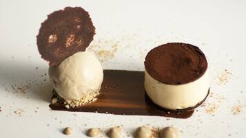 Postre con helado y elementos de chocolate sobre un plato blanco.
