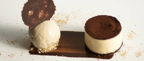 A dessert with ice cream and chocolate elements on a white plate.