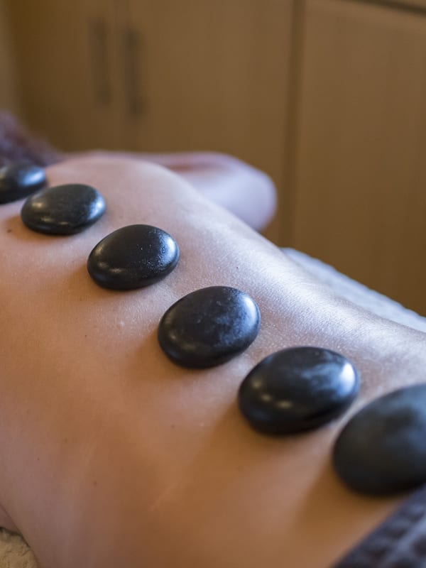 Experience a rejuvenating massage with expert therapists, offering soothing back massages with heated stones.