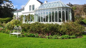 Une grande maison blanche avec une véranda en verre.