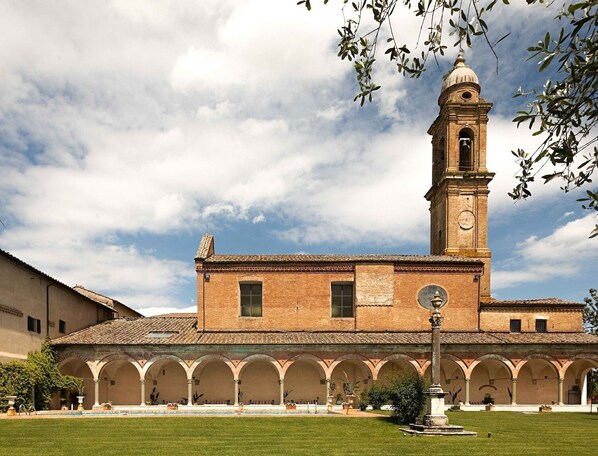 A historic building with a central tower and arched colonnade.