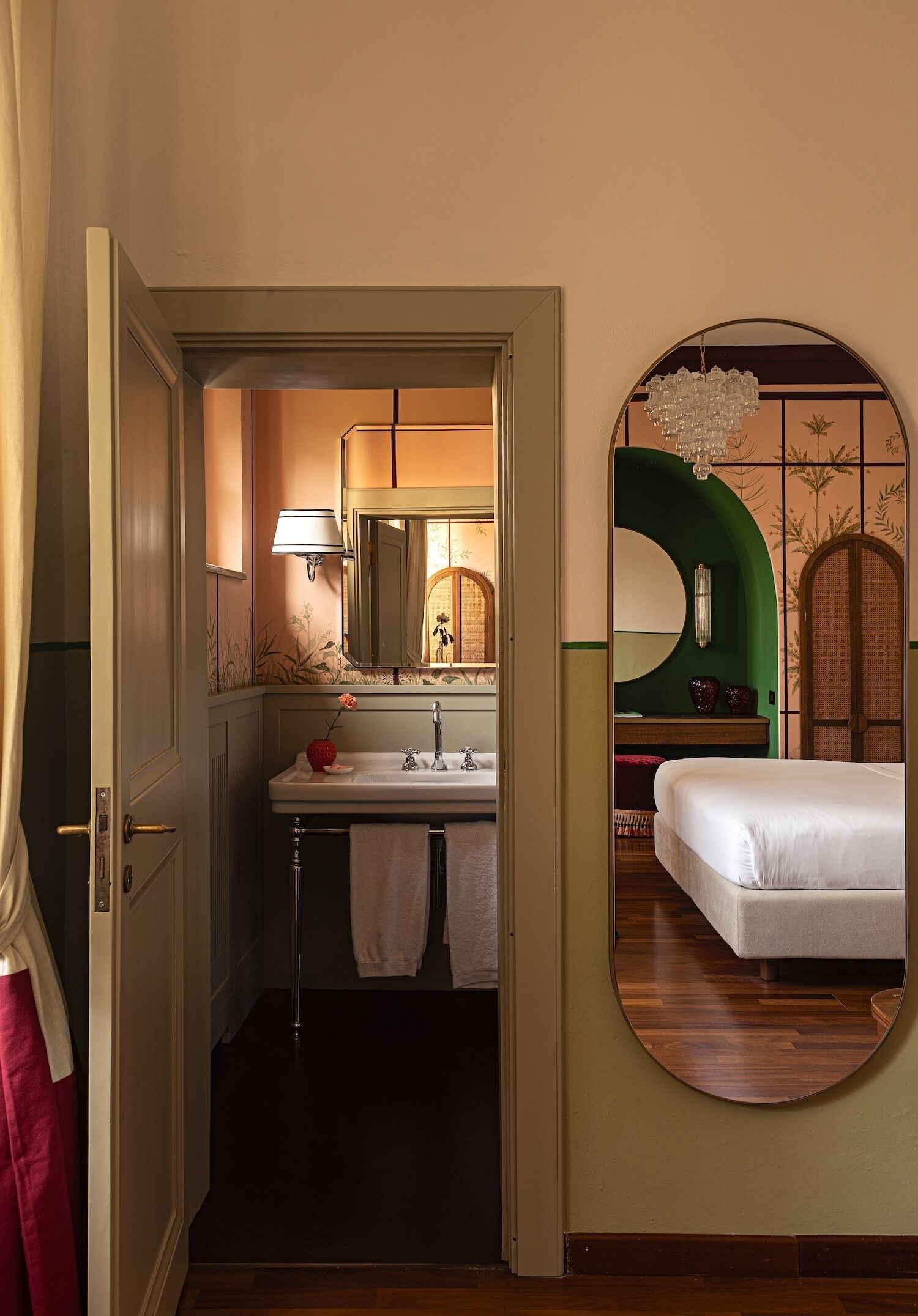 Een hotelkamer met een badkamer, een bed en een spiegel.